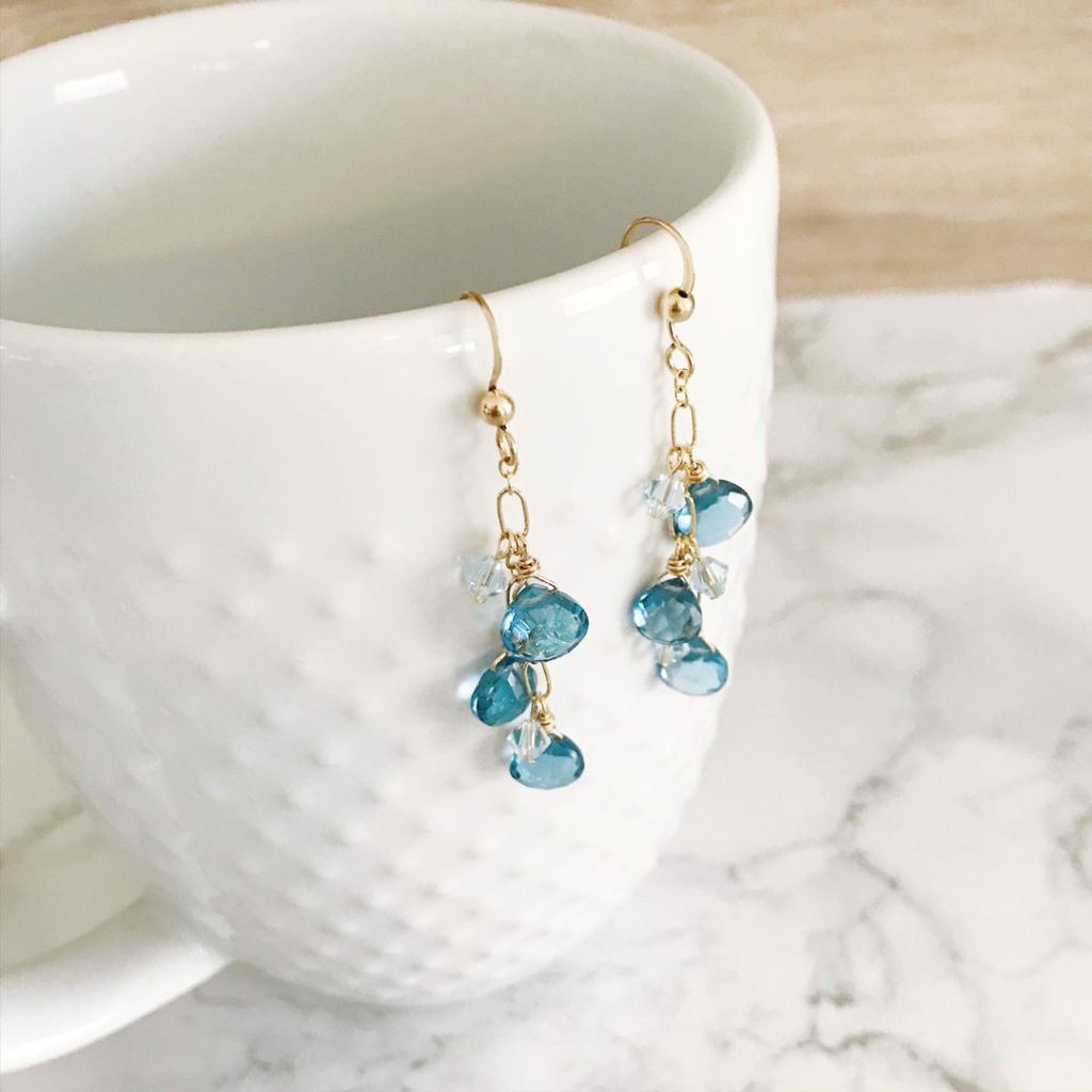 London Topaz cluster earrings 14kt gold hanging on white cup