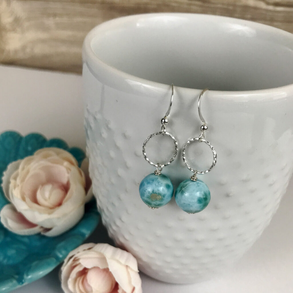 Larimar and sterling earrings hanging on white cup